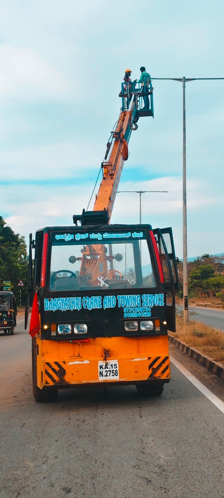 ಮ್ಯಾನ್ ಲಿಫ್ಟ್ನಿಂದ ಬೀದಿದೀಪ ನಿರ್ವಹಣೆ — Crane-mounted personnel basket for streetlight maintenance near Bhatkal